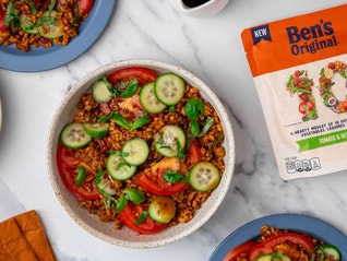 Ben's 10 Medley rice package - Tomato & Herbs flavor - on table next to plates of Tomato Cucumber Salad